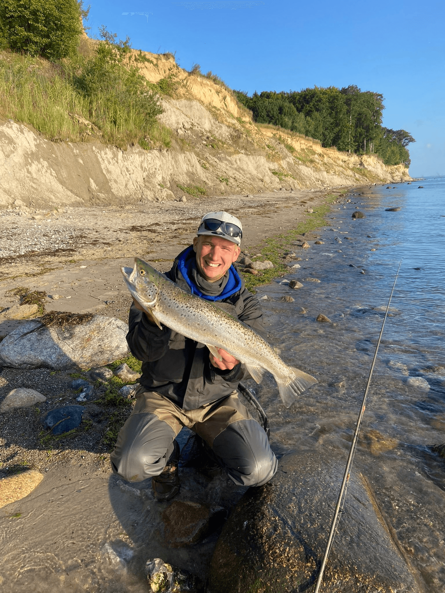 Benny am Ufer mit gefangener Meerforelle